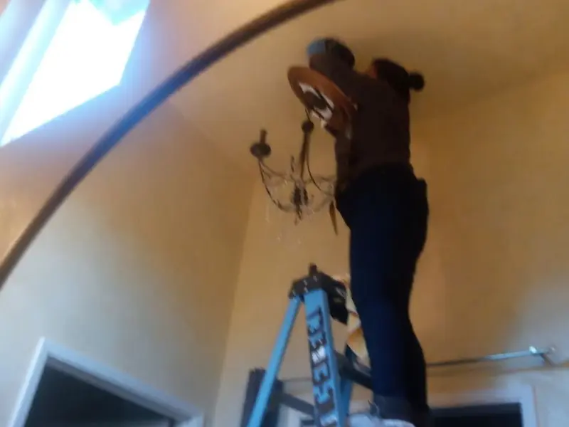 Electrician installing a chandelier in a Edenton residence